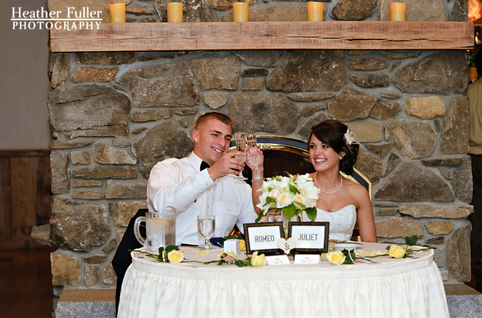 bride-groom-toasts-head-table-fireplace-zukas-hilltop-barn-wedding-reception-venue